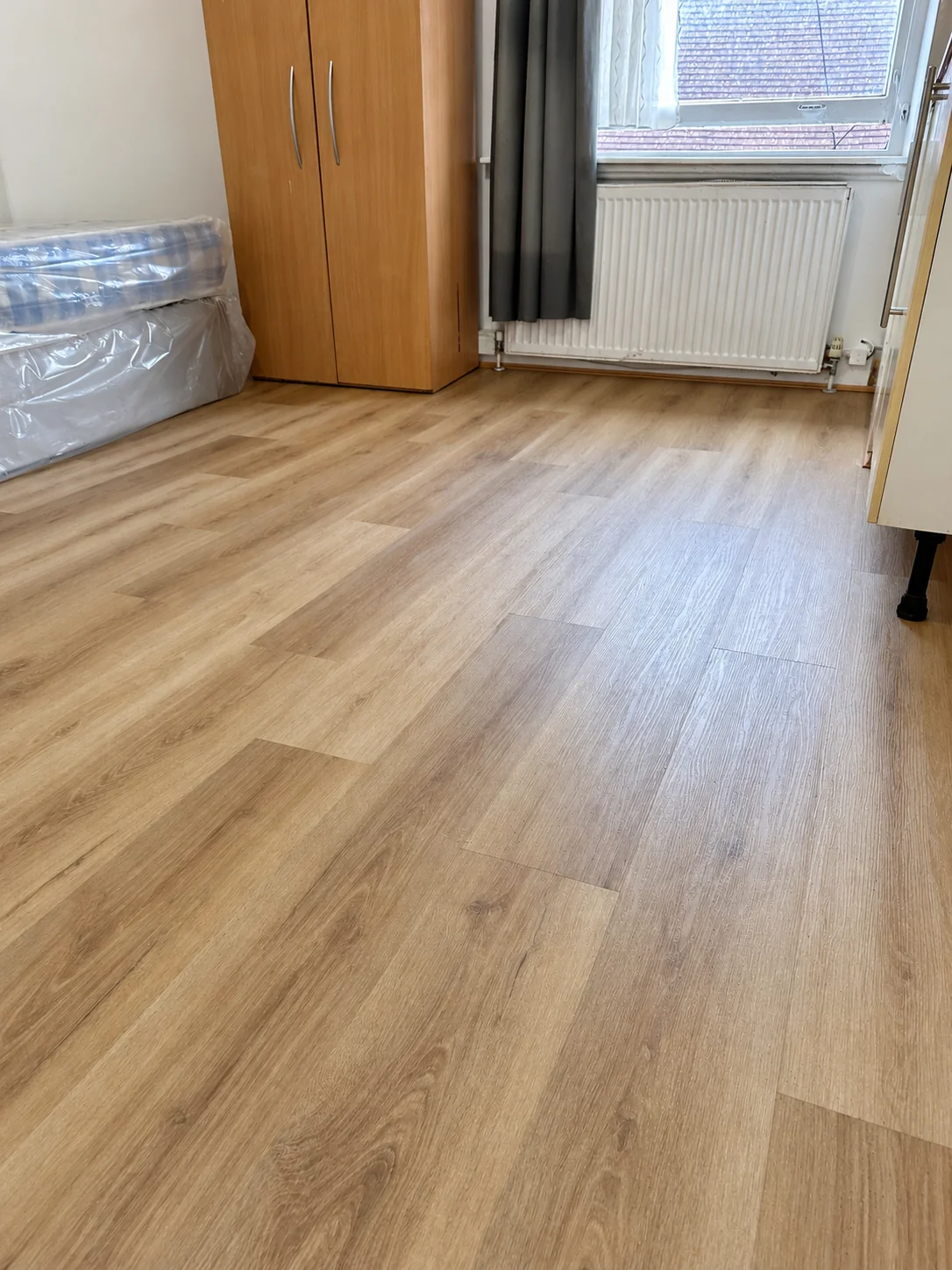 Natural brown SPC fitted throughout the room, with warm wood tones and a continuous plank finish.