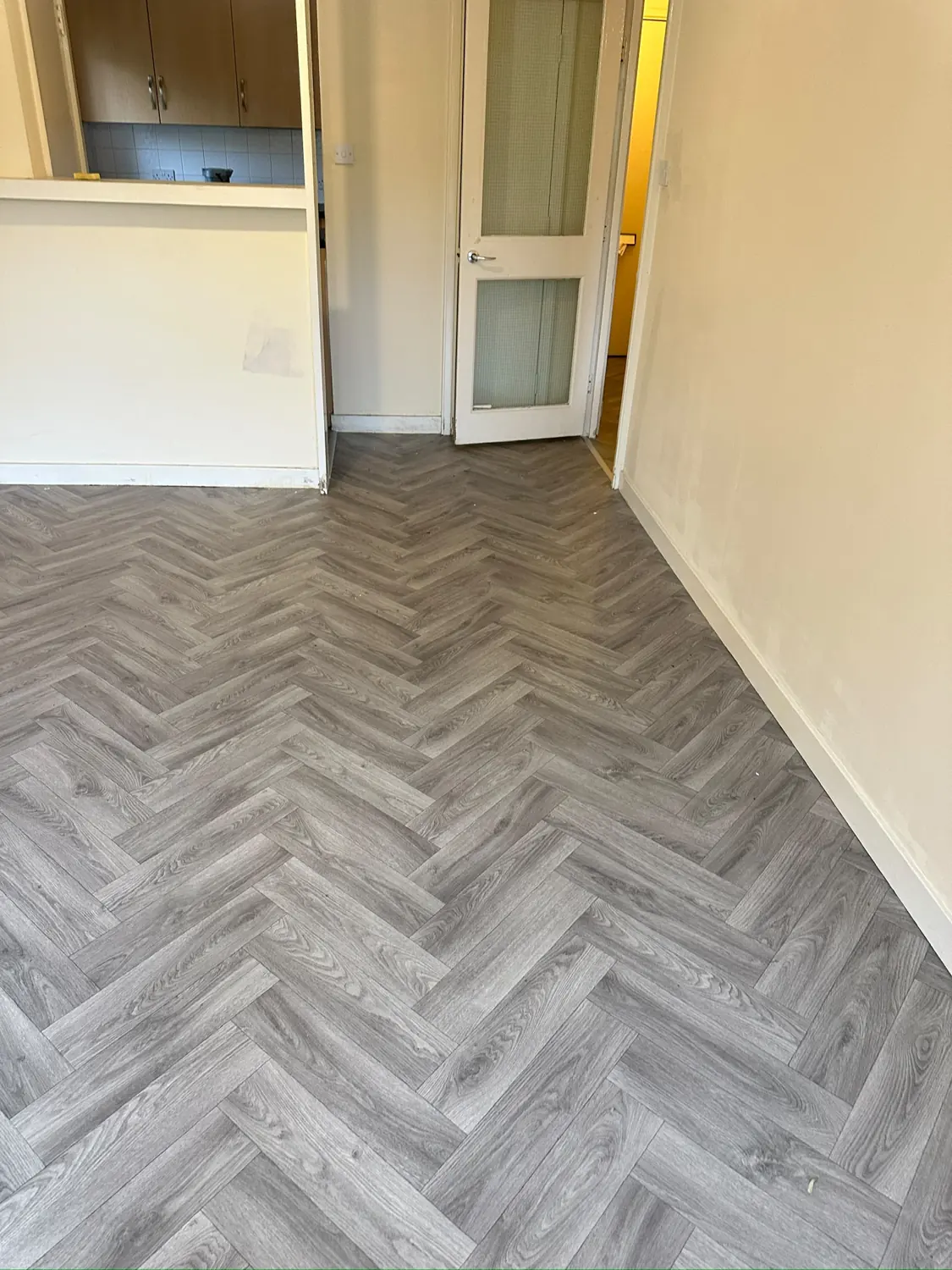 A continuous herringbone look, finished neatly at the doorway.